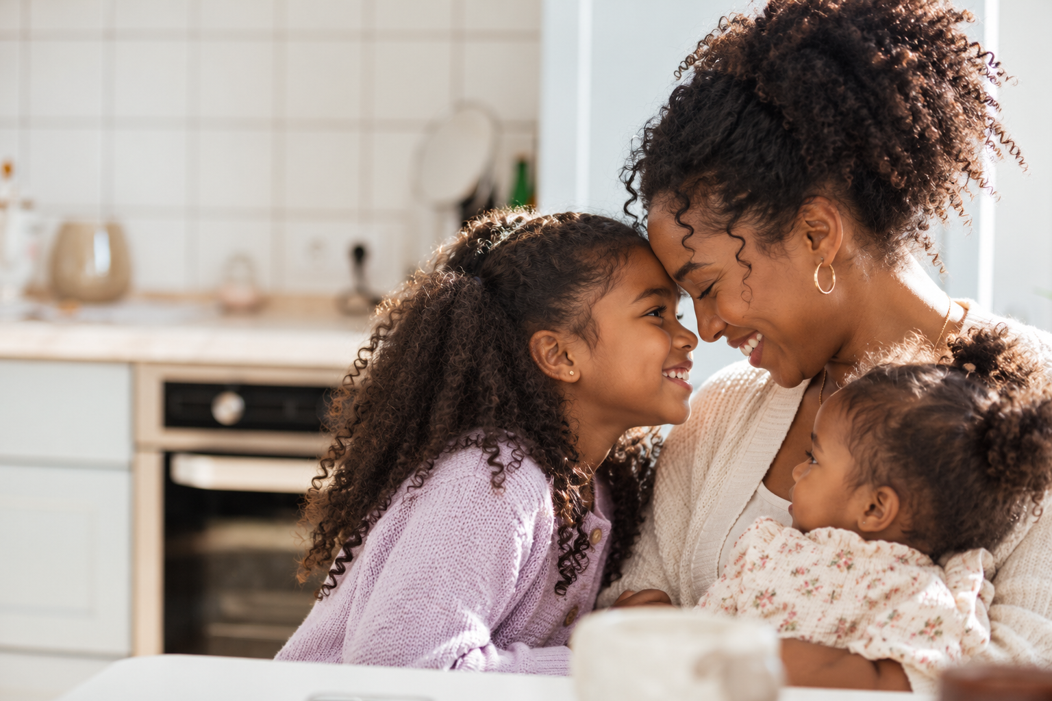 Mother embracing her daughters at home